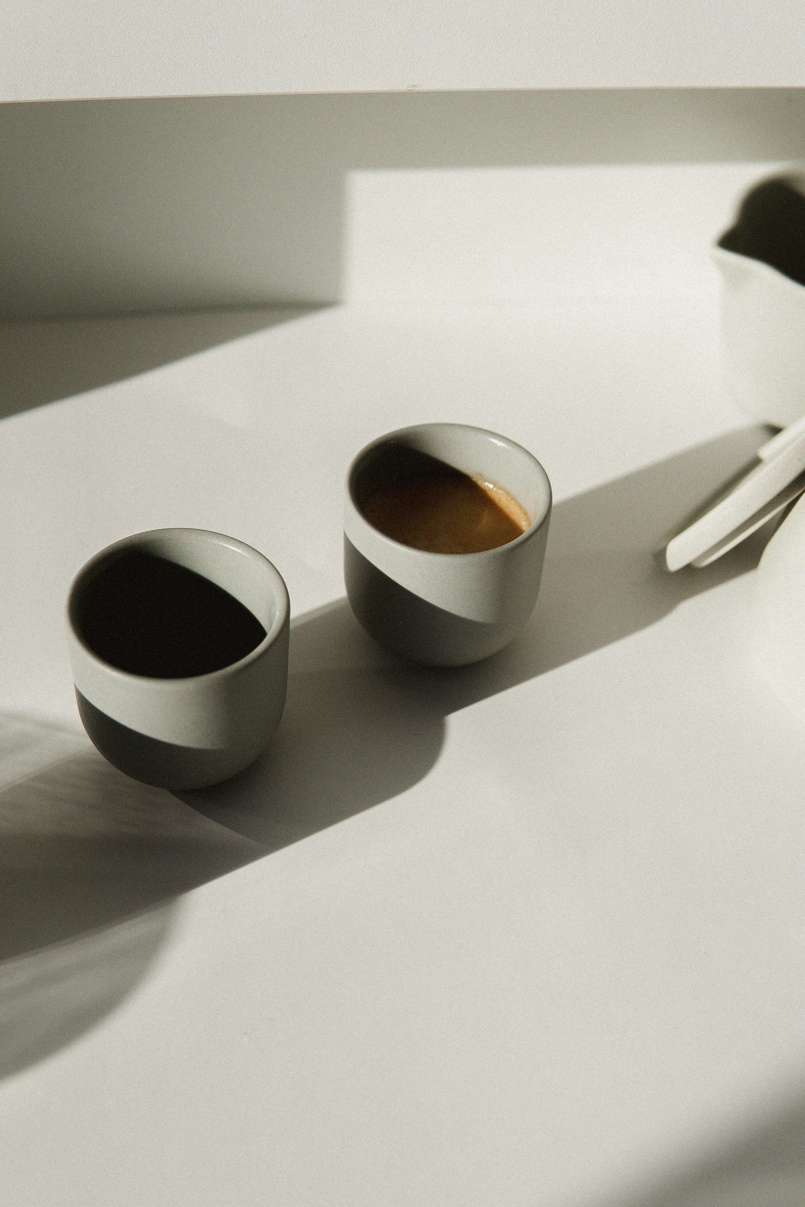 2 white ceramic mugs on white table